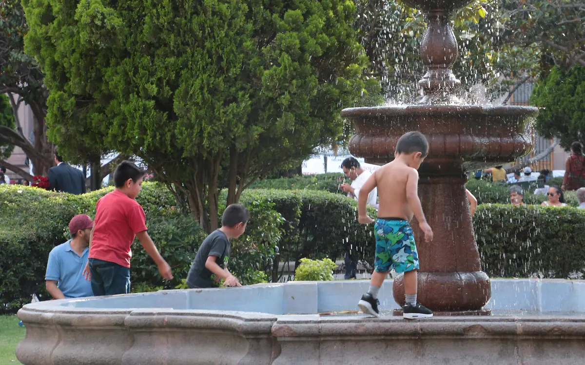 QUE CALOR,  NIÑO SE REFRESCA EN FUENTES DE PLAZA DE ARMAS